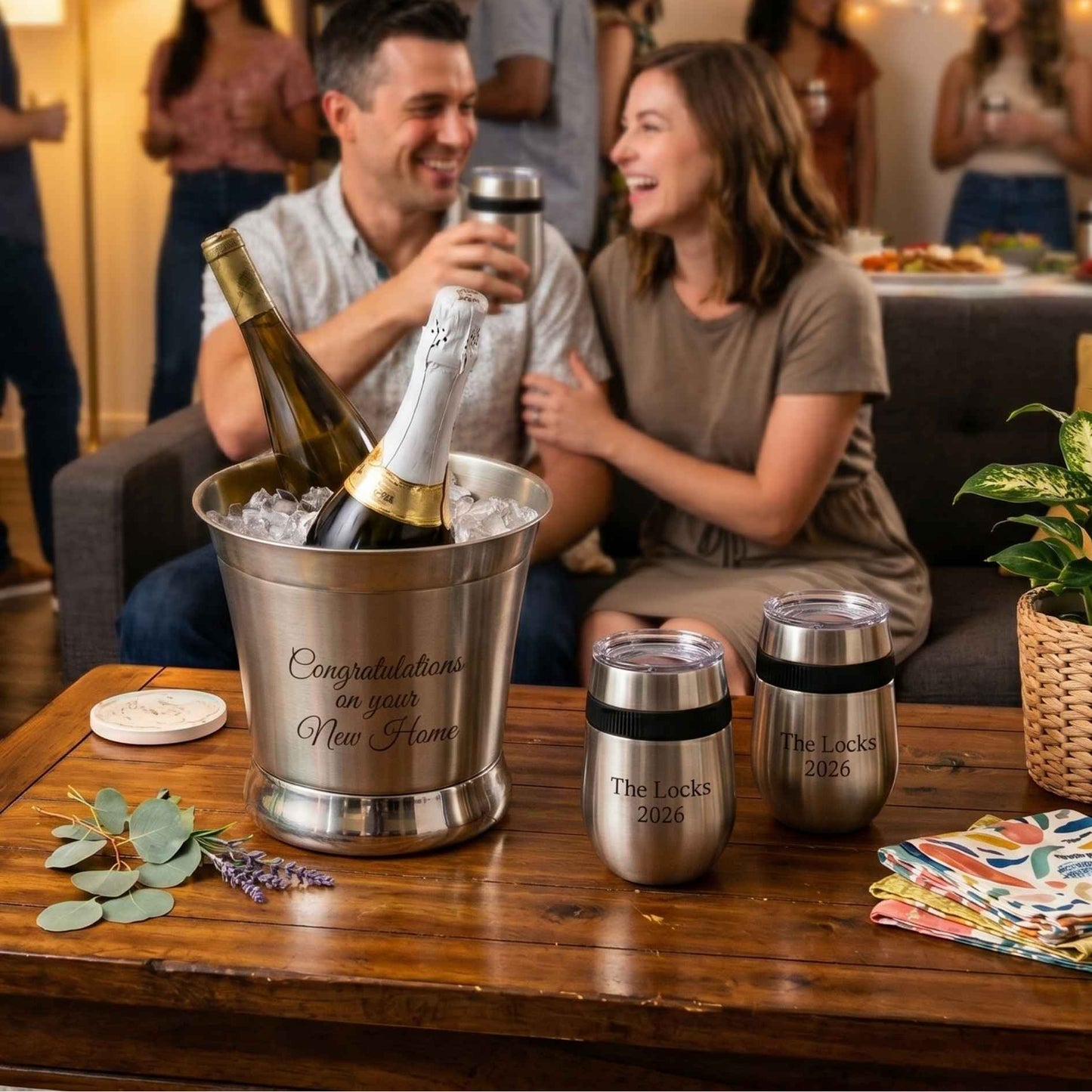 engraved stainless steel ice bucket and stemless glasses on table at a house party