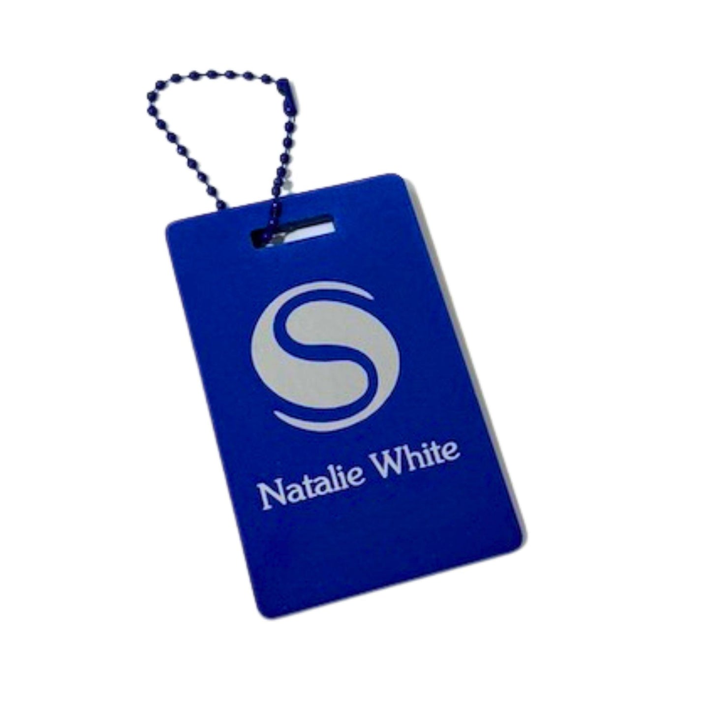 A blue rectangular luggage tag with a matching blue ball chain, featuring a white stylized 'S' logo and the name 'Natalie White' printed on it, set against a plain white background.