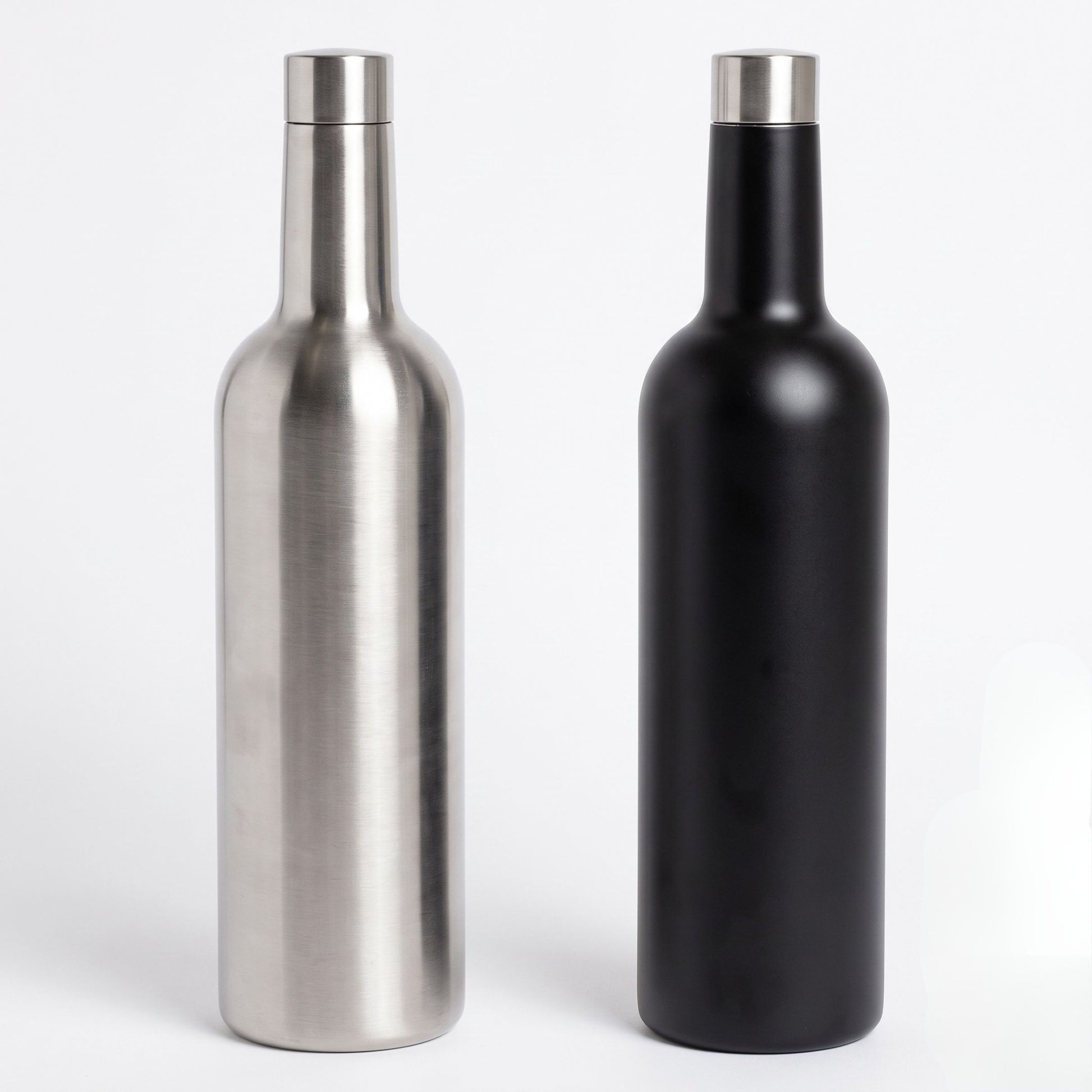  bottle-shaped flasks with narrow necks and silver caps, shown side by side on a light gray background. The left container has a brushed metallic silver finish, and the right container has a matte black finish.