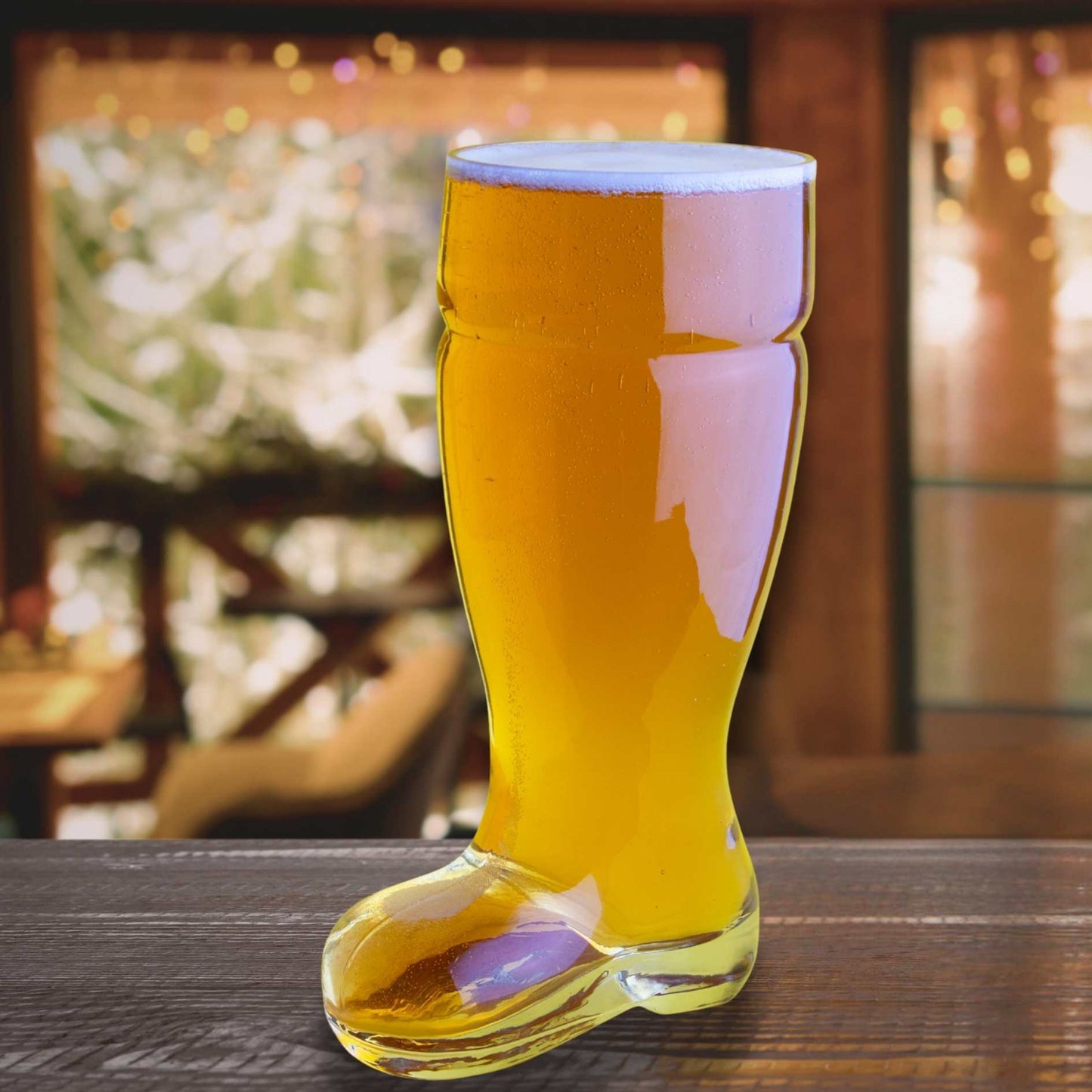 Glass boot filled with beer on a wooden table with a blurred background