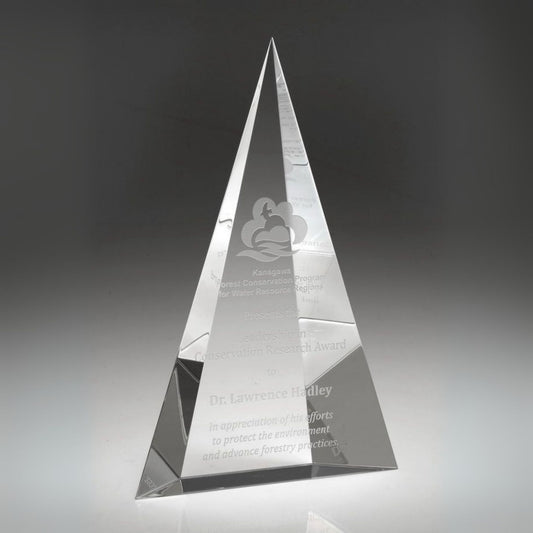 Crystal pyramid award with engraved text on a dark background