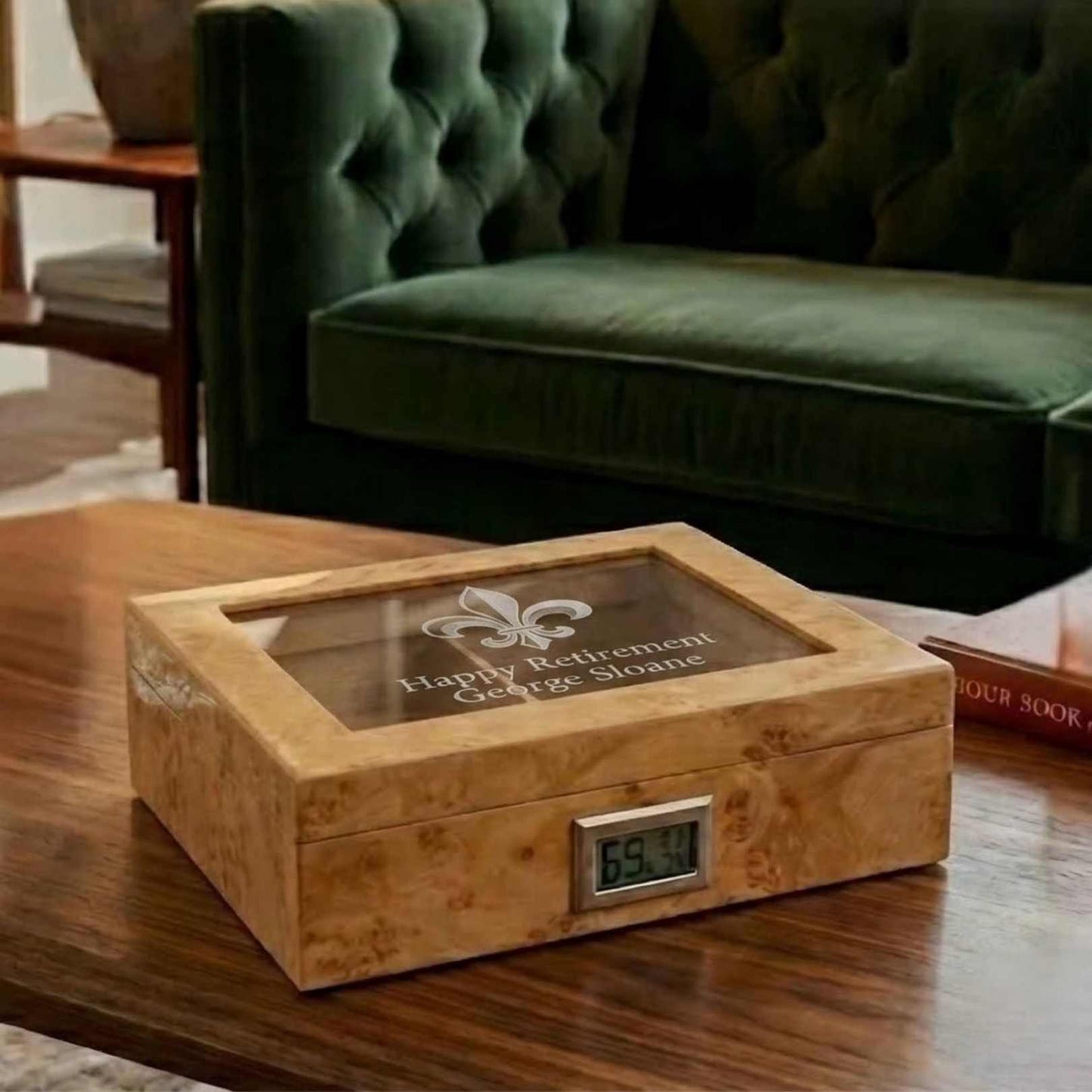 Wooden humidor with digital thermometer on a wooden table, green velvet chair in the background
