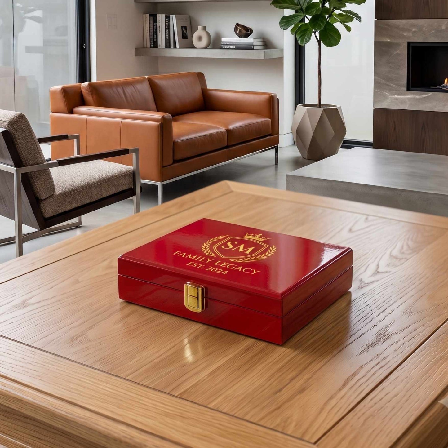 A glossy red wooden keepsake box with a gold clasp and a gold crest design on the lid, placed on a light wood table in a modern living room setting.