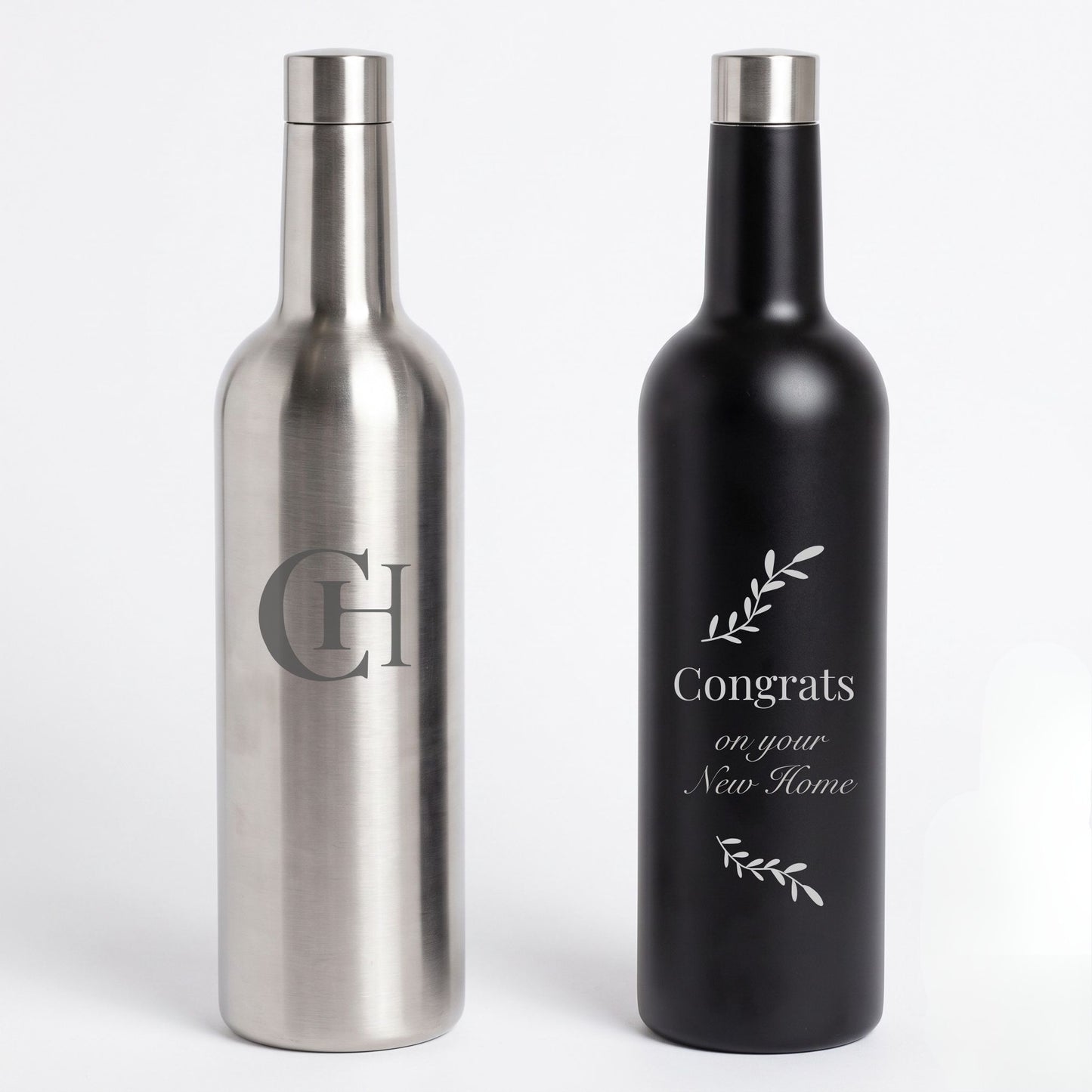 Two bottle-shaped flaskson a light gray background, one brushed silver with a large engraved monogram and one matte black with a white 'Congrats on your New Home' design.