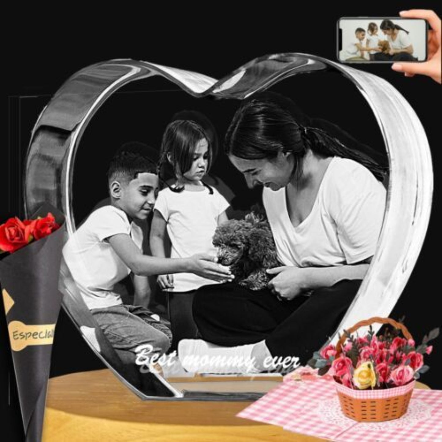  heart-shaped 3 d black-and-white photo of a woman, children, and a dog. A hand holds a phone in the top-right corner, and flower bouquets and a basket are placed around the base.