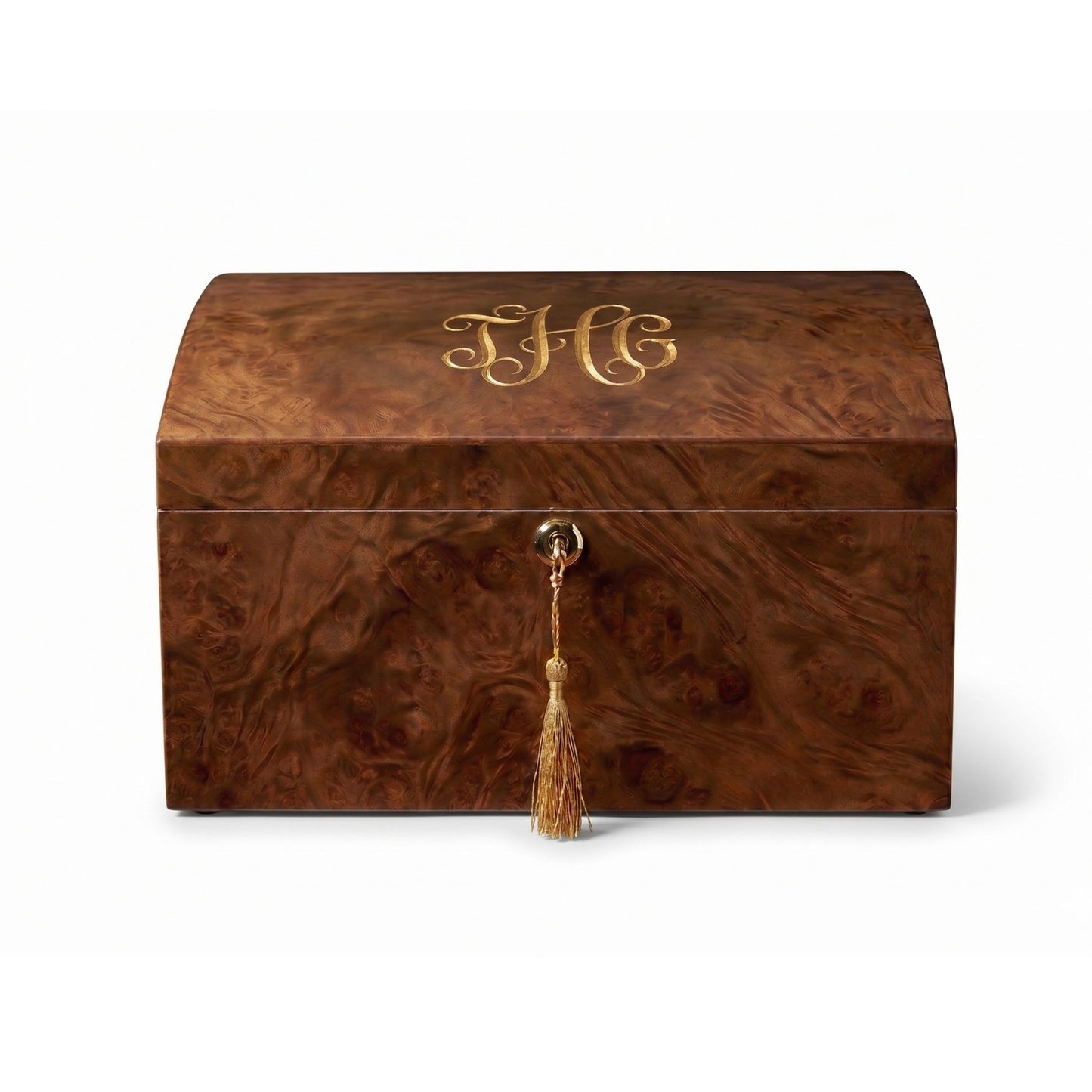 Woodenn humidor box with gold monogram and tassel on a white background