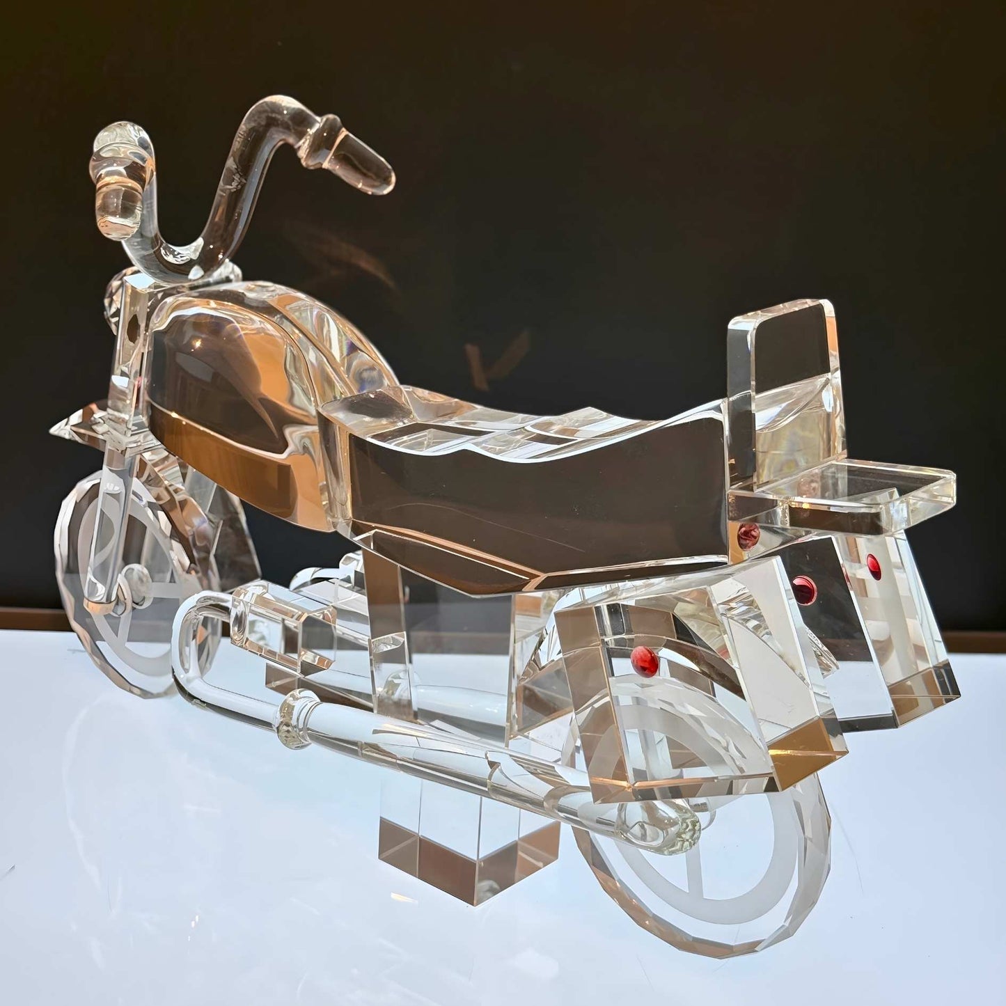 Clear motorcycle model on a reflective surface with a dark background