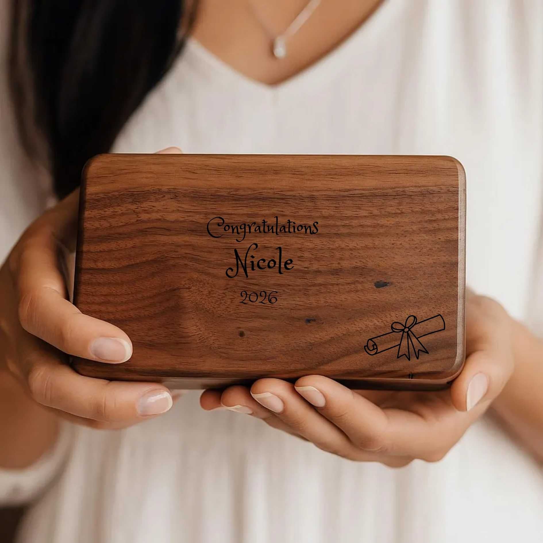 Wooden jewelry box with engraved text held by a person