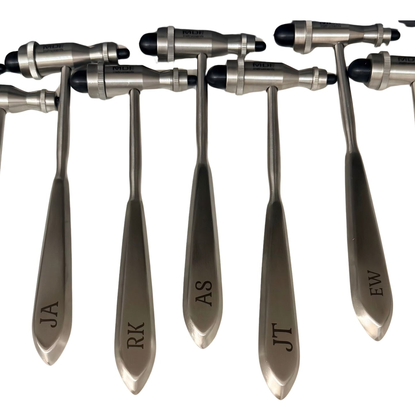 Five stainless steel personalized medical instruments with engraved names (JA, RK, AS, JT, EW) on their handles, arranged in a row against a white background.