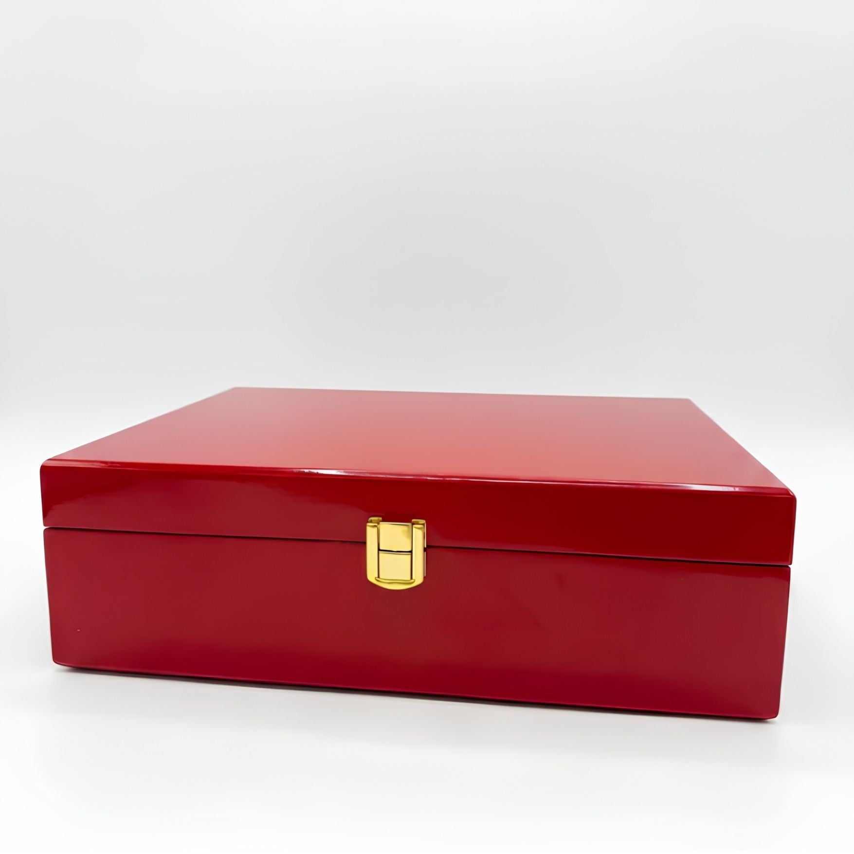 A glossy red rectangular storage box with a gold latch closure, photographed on a clean white studio background.